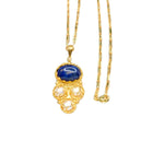 Gold colored necklace with a blue pendant and pearl-like elements with elongated link chain