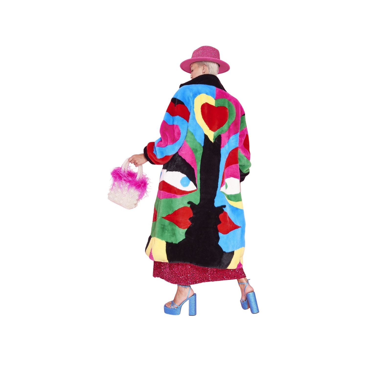 Person wearing a colorful fur like long length coat with heart and face patterns on a white background