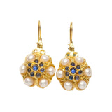 Gold flower shaped earrings with pearl like beads and blue stones on a white background