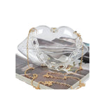 clear lip shaped purse with gold colored chair strap