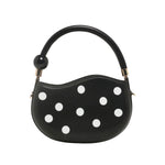 Black round handbag with white polka dots