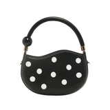 Black round handbag with white polka dots