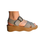 Gray sandal with a brown platform sole and brass buckle closure