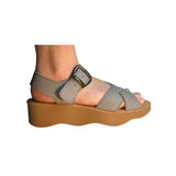 Gray sandal with a brown platform sole and brass buckle closure