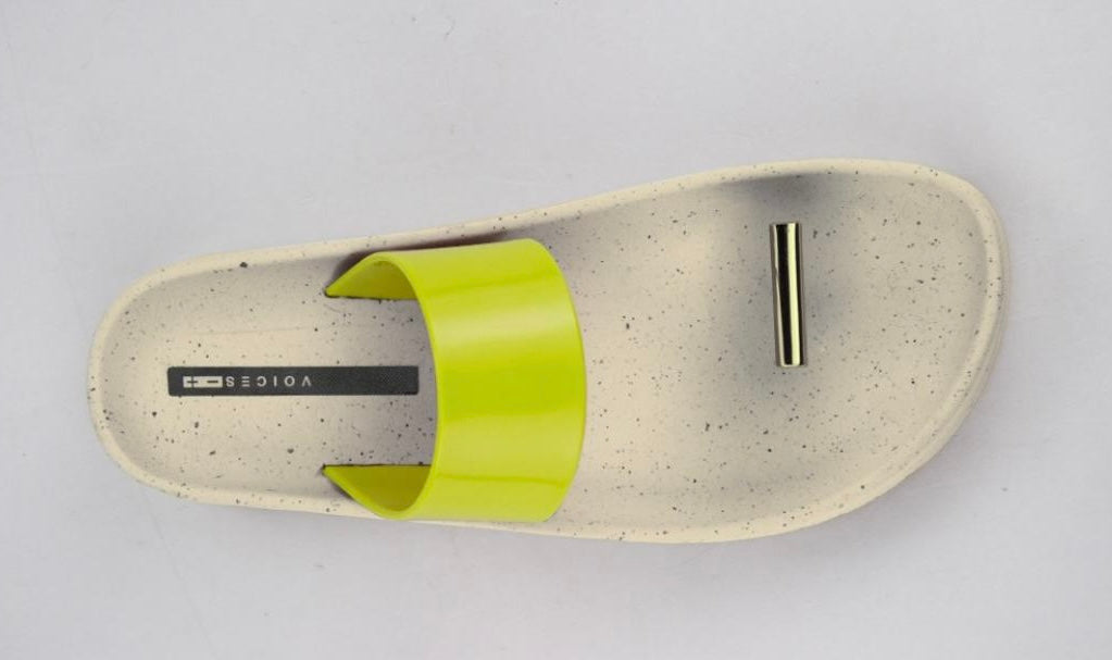 Beige sandal with yellow strap and a metallic toe catch close-up